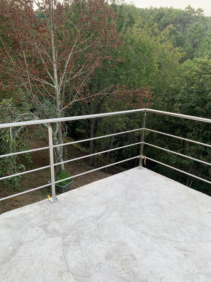 Barandilla de acero inoxidable en terraza con vistas al bosque en A Coruña